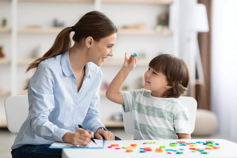 cute-little-boy-showing-pronouncing-sound-o-with-his-teacher-exercising-together-classroom