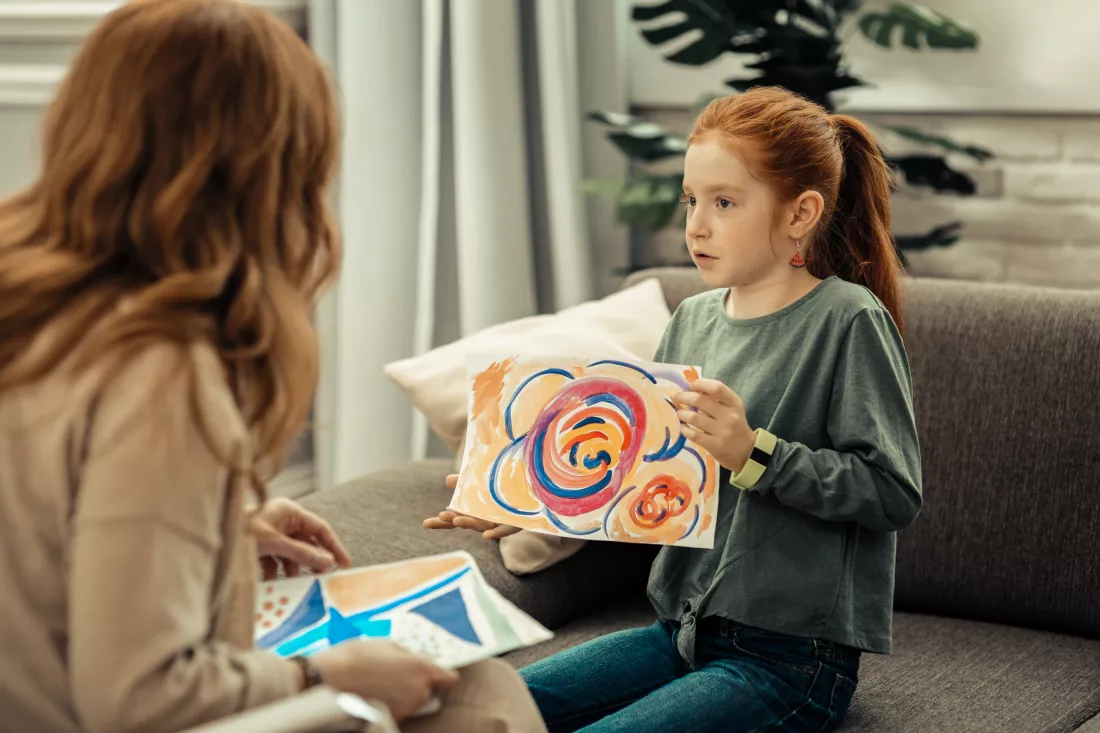 psychological-test-cute-pleasant-girl-holding-colorful-painting-while-speaking-about-it