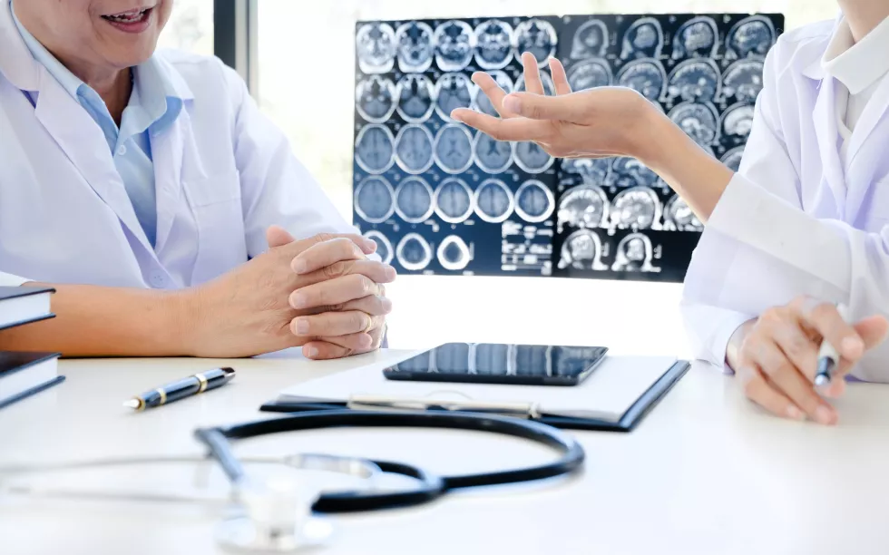 midsection-doctor-discussing-with-colleague-desk-hospital